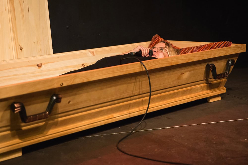 Katja Hofmann modeertiert den Death Slam liegend im Sarg, Foto: Julia Fenske
