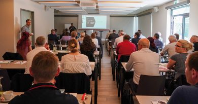 Symposium mit Teilnehmenden indoor, Blick von hinten