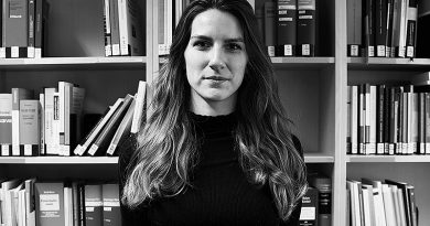 Portraitfoto Barbara Maria Hasenau, s/w, vor Jura-Bücherregal