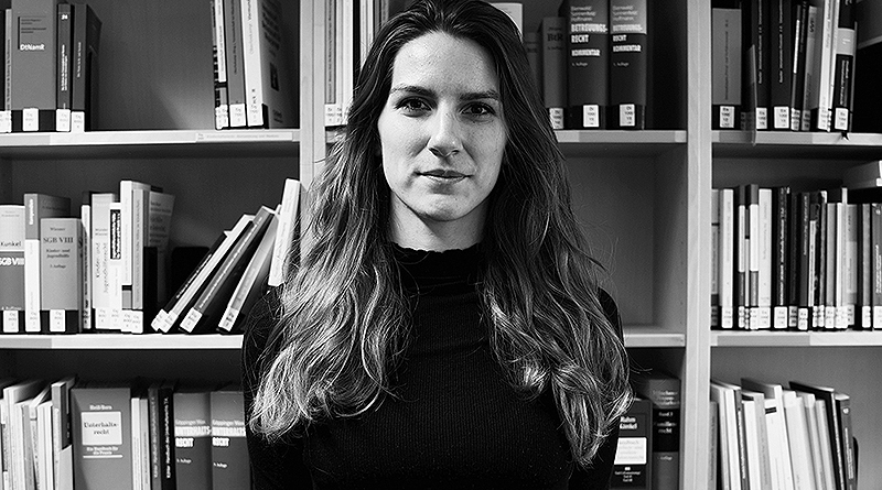 Portraitfoto Barbara Maria Hasenau, s/w, vor Jura-Bücherregal