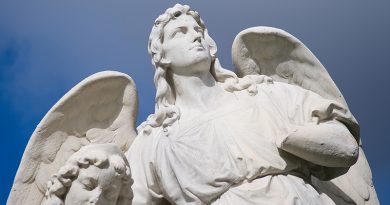 Foto von Lara Schink, Engelskulptur auf dem Friedhof vor blauem Himmel