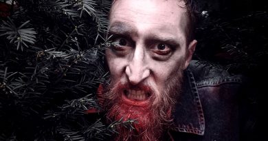 Jan Schwarzkamp als Zombie schaut aus einem Gebüsch