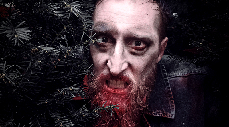 Jan Schwarzkamp als Zombie schaut aus einem Gebüsch