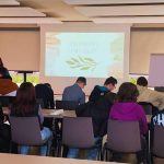 Innenraum Zentrum für Endlichkeitskultur, Jeanette Heller steht vor einer Klasse und hält einen Vortrag